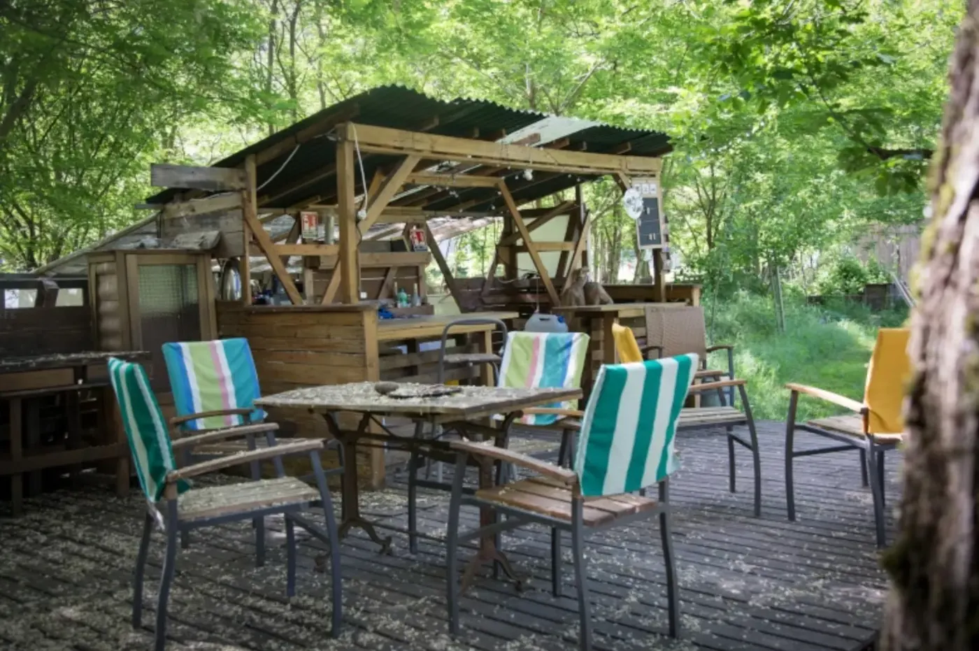La buvette en bois du jardin, chaises et table sous les arbres